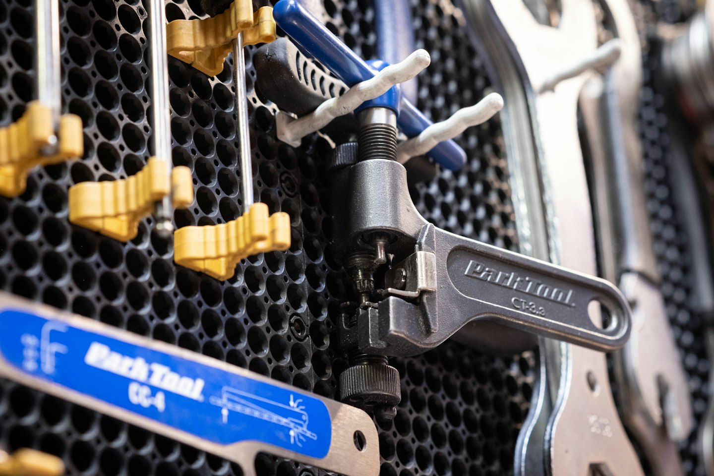 Bicycle repair tools hanging on a workshop pegboard.